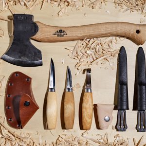 The Complete Craving kit with quality Swedish knives from Morakniv and a hand-forged axe from Gransfors Bruk in a lfat lay on plywood