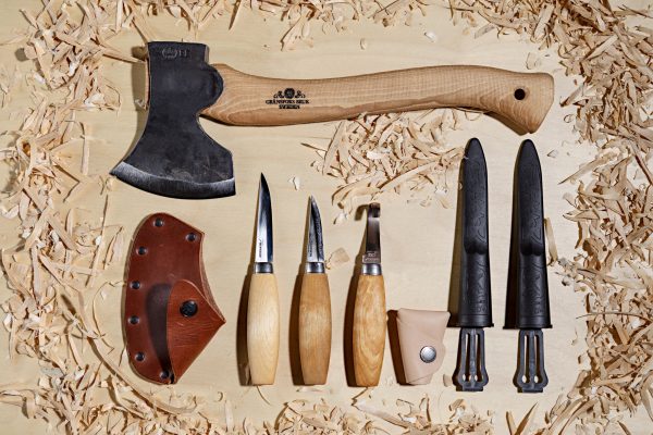 The Complete Craving kit with quality Swedish knives from Morakniv and a hand-forged axe from Gransfors Bruk in a lfat lay on plywood