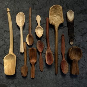 hand carved wooden spoons by Nat Ord laid flat on dark background