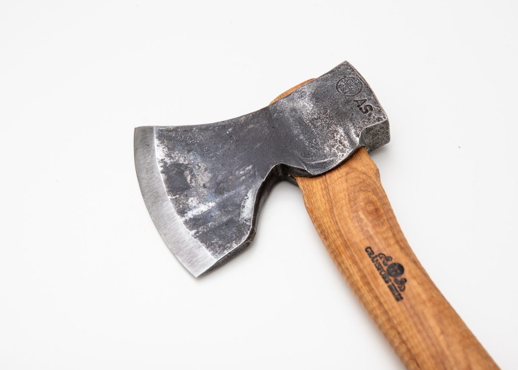 Hand-forged Gränsfors Small Carving Axe with its vegetable-tanned leather sheath, ideal for sloyd and spoon carving.